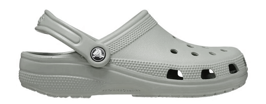 A pair of grey Crocs Classic Clogs with closed toes and open sides, featuring a comfortable and lightweight design.